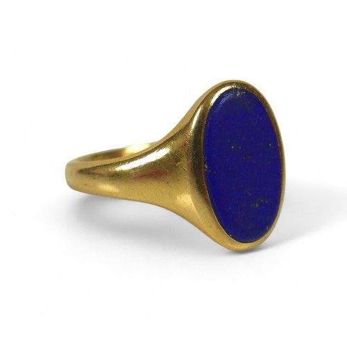 131 - A George V 18ct gold and lapis lazuli signet ring, with flat oval central stone, 12 by 7mm, London 1... 