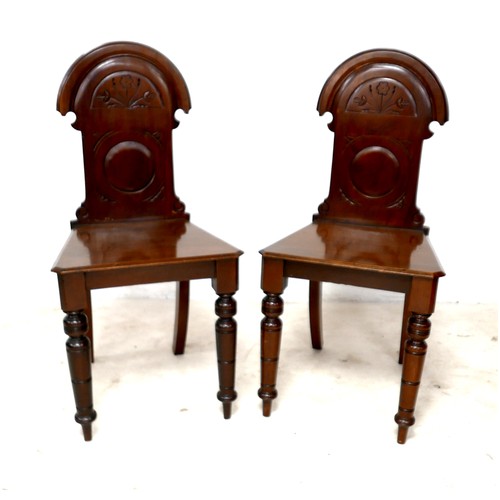 532 - A pair of Victorian mahogany hall chairs, with carved decoration to the shaped backs, each 43 by 40 ... 