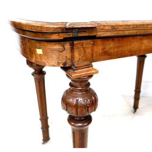 539 - A Victorian walnut fold over card table, with swivel top, inlaid decoration, raised on column suppor... 