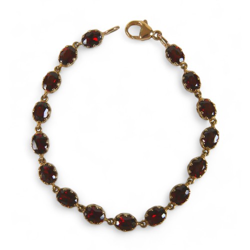 95 - A 9ct gold and garnet bracelet, set with sixteen oval garnets, marked 9k, each stone 8 by 5mm, 10.3g... 