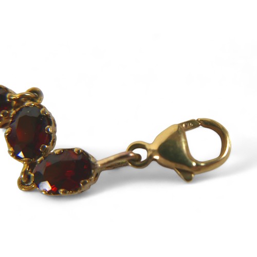 95 - A 9ct gold and garnet bracelet, set with sixteen oval garnets, marked 9k, each stone 8 by 5mm, 10.3g... 