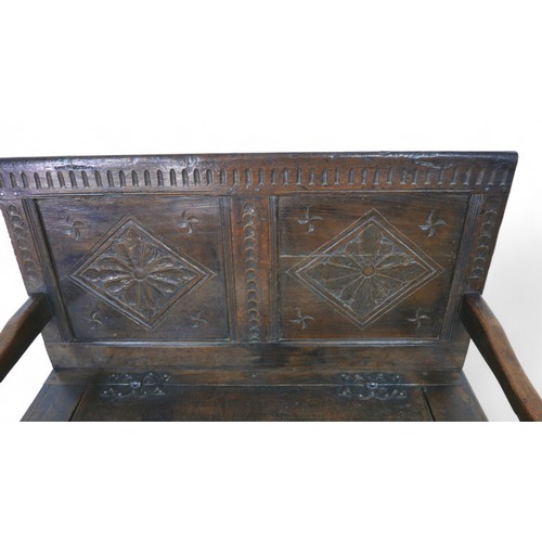 341 - An oak hall bench with a carved panel back and lift up seat, 106 by 57 by 105cm high.