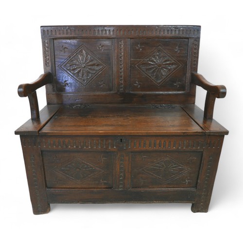 341 - An oak hall bench with a carved panel back and lift up seat, 106 by 57 by 105cm high.