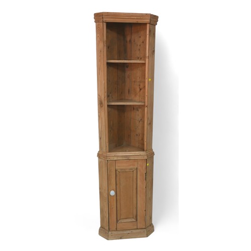 296 - A slim stripped pine corner cupboard, with an open shelved top above a cupboard door, 29 by 29 by 17... 