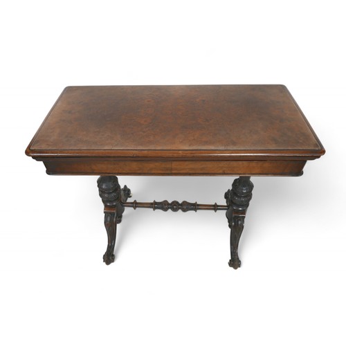 344 - A Victorian burr walnut fold over top card table, on turned and carved pillar supports united by a t... 