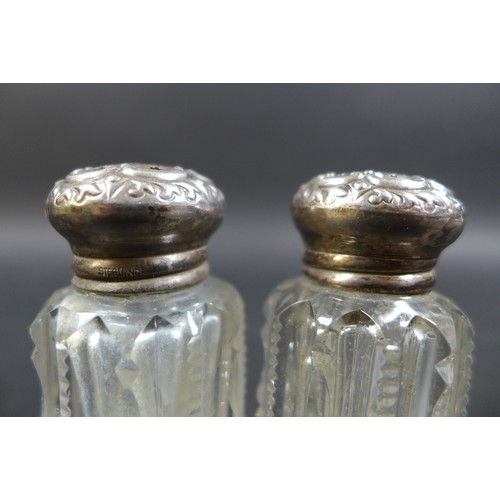 13 - A collection of six silver top bottles, including a perfume bottle, and two with pierced lids, the l... 