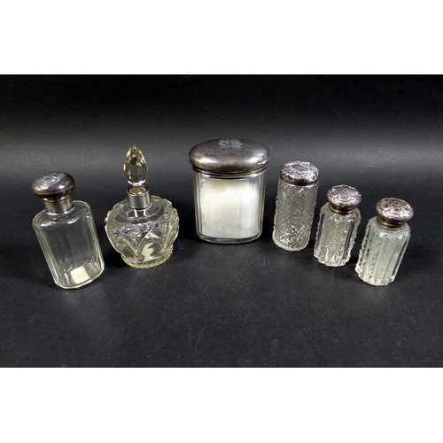 13 - A collection of six silver top bottles, including a perfume bottle, and two with pierced lids, the l... 