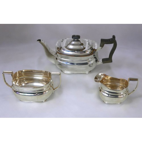 6 - A George V three-piece silver tea set, comprising teapot, 28 by 12 by 13cm high, twin handled sugar ... 