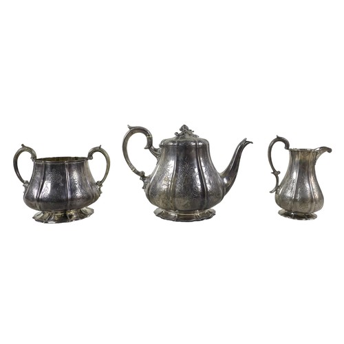 35 - A Victorian three piece tea set, of bombe shape with engraved decoration, the teapot with acorn fini... 