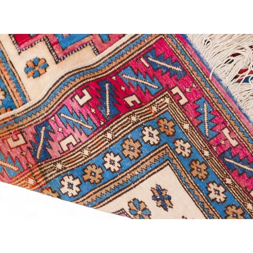 290 - A hand knotted Persian woolen rug with a cream field and geometric design,107 by 190cm.