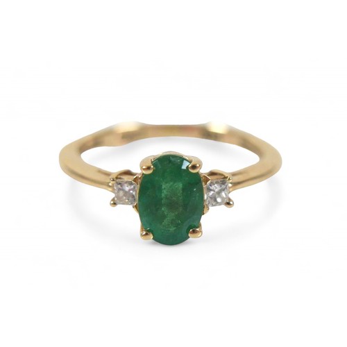 85 - A 14k yellow gold Colombian emerald ring, the oval cut stone 7 by 5 by 4mm, flanked by two 2mm princ... 