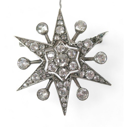 71 - A zircon and white metal starburst brooch, with safety chain,  4 by 3cm.