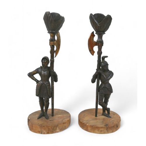 156 - A pair of Victorian bronze figural candlesticks, each modelled as a man in a suit of armour holding ... 