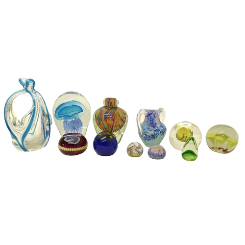 129 - A group of nine glass paperweights, various designs including canework, the largest a dump weight wi... 