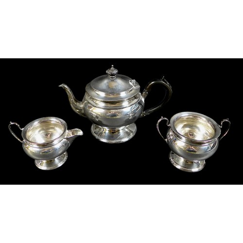 4 - A George V silver three piece tea service, comprising teapot on circular foot, with ebonized handle,... 