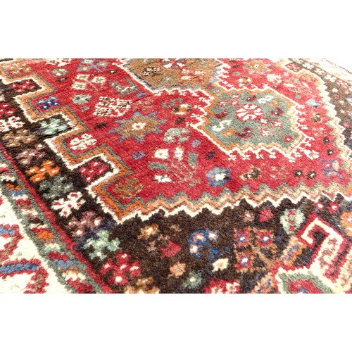 315 - A small woolen rug with red ground, stepped corners, crenellated design, brown spandrels, cream ribb... 