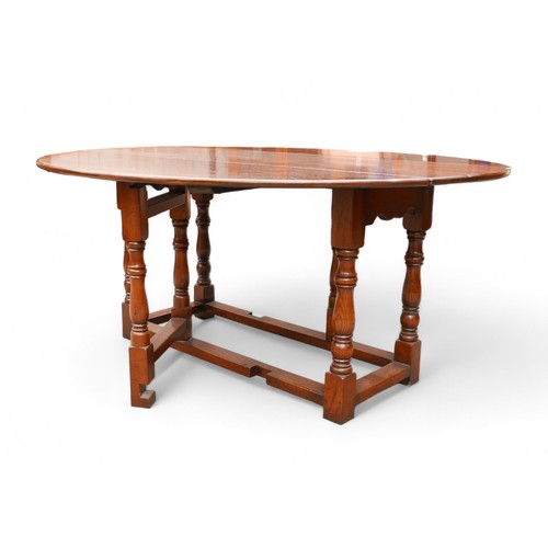 343 - An 18th century style oak drop leaf dining table, 167 by 148 extended by 76cm high.