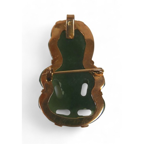 27 - A New Zealand Maori Hei-tiki carved jade pendant in a gold brooch/pendant mount, tests to 18ct marke... 