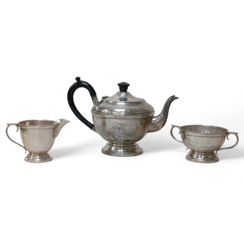 83 - A George V and later silver bachelor's associated three-piece tea service, comprising a teapot with ... 