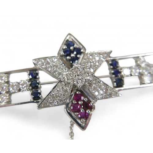 54 - A sapphire, ruby and diamond set 18ct white gold brooch, comprising a open bar form with six sided s... 