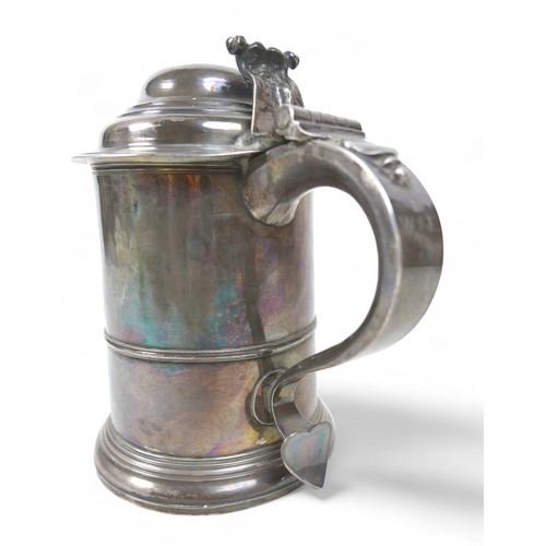 85 - A George II silver lidded tankard, domed cover, scroll thumbpiece, skirted base, engraved to handle,... 