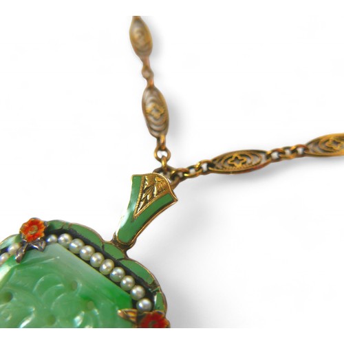 11 - A 14ct yellow gold mounted carved jade pendant with seed pearl and enamel border on a 14ct fancy lin... 