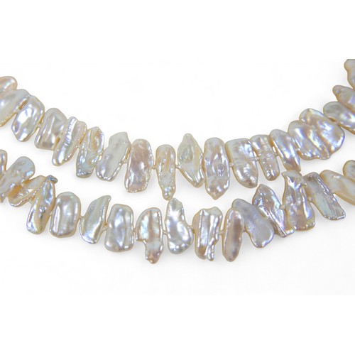 33 - A double strand baroque pearl necklace, the strands having 77 and 72 pearls are joined by a 9ct gold... 