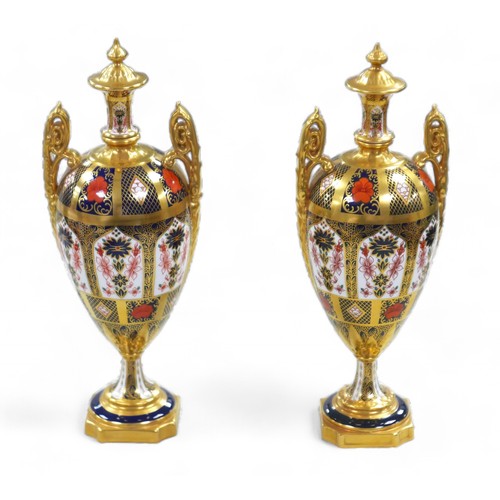 196 - A pair of Royal Crown Derby Old Imari 1128 patter twin handled urns, both 30.5cm high. (2)