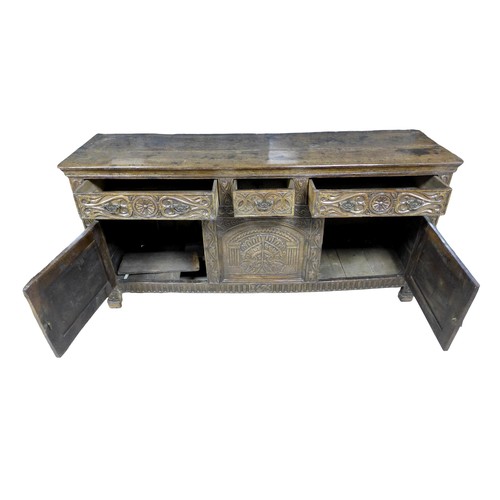 357 - An antique carved oak dresser base, dated 1675 with three frieze drawers above two cupboard doors an... 