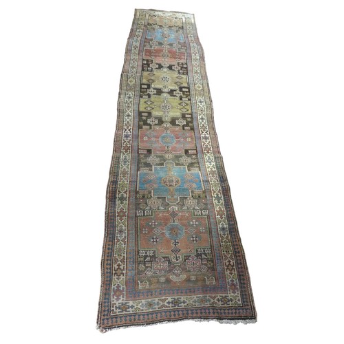 359 - A long woolen hand knotted runner rug, with stylised triple border, 466 by 107cm.