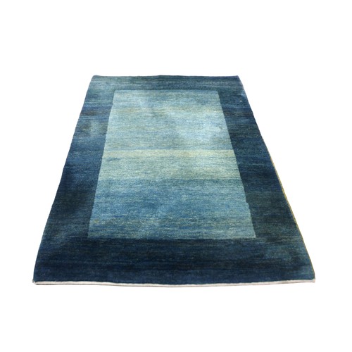 365 - A Gabbeh rug with a dark green teal border and a green central rectangle, 245 by 179cm.