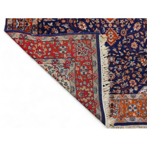 338 - A woolen rug with a blue field and stylised border, 128 by 200cm.