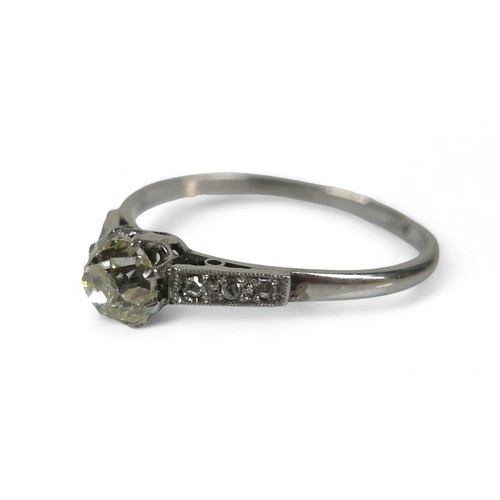 59 - A platinum diamond solitaire ring, set with small diamonds to the shoulders, the central diamond mea... 