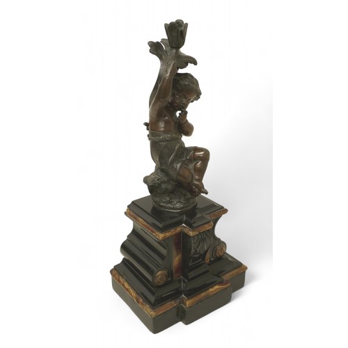 170 - A bronze figure of a putti on a rocky outcrop on marble base, 20 by 15 by 45cm high.