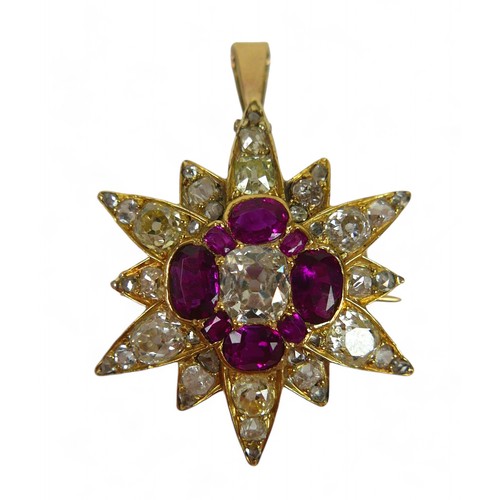 A diamond and ruby star form pendant/brooch, with central elongated cushion cut diamond, 5 by 6mm, surrounded by over thirty smaller cut diamonds of different sizes, yellow metal mount, 2.6 by 3.6cm overall (including loop), 5.3g.