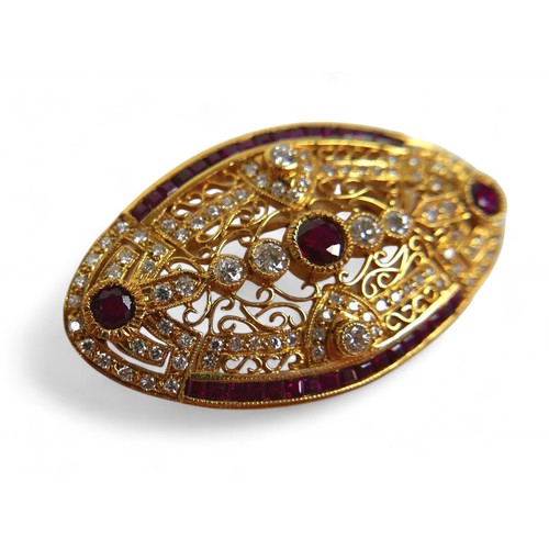 3 - An 18ct gold diamond and ruby oval form brooch, with round cut diamonds and rubies central round cut... 