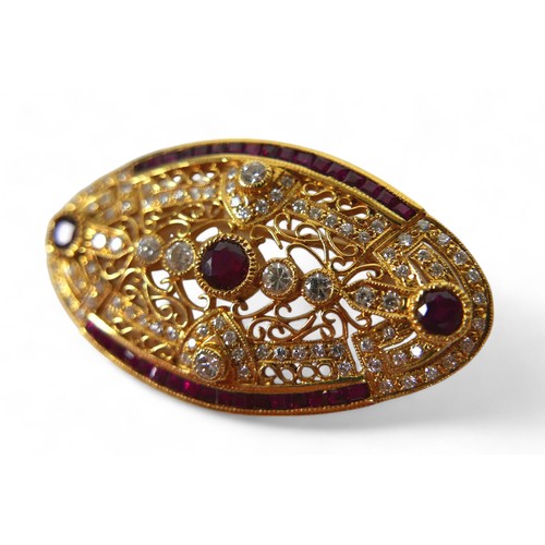 3 - An 18ct gold diamond and ruby oval form brooch, with round cut diamonds and rubies central round cut... 