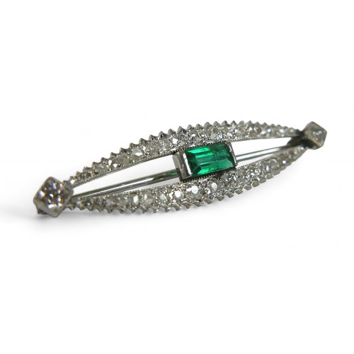 51 - A white gold emerald and diamond bar brooch, emerald 3.5 by 5mm, 3.8cm wide, 3.1g.