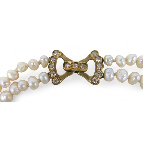 9 - A pearl necklace with 9ct gold and diamond clasp, with two strands of irregular pearls, approximatel... 