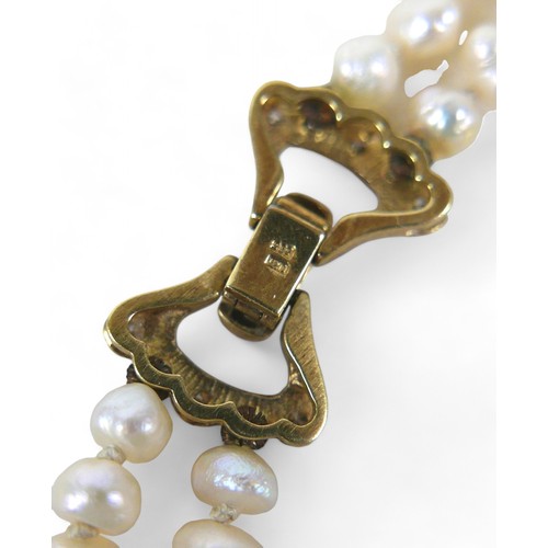 9 - A pearl necklace with 9ct gold and diamond clasp, with two strands of irregular pearls, approximatel... 