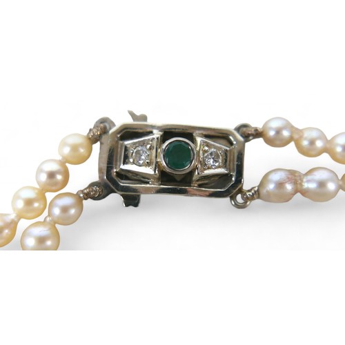 10 - A pearl necklace with 14ct white gold diamond and emerald clasp, the round cut emerald3mm diameter, ... 