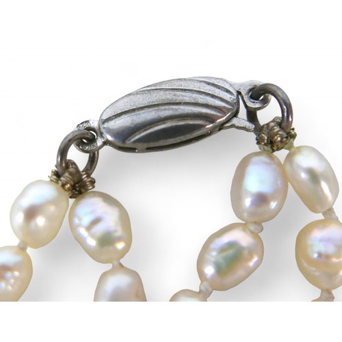 32 - Three pearl necklaces, including a two strand necklace with irregular pearls, 68cm long, 110.9g gros... 