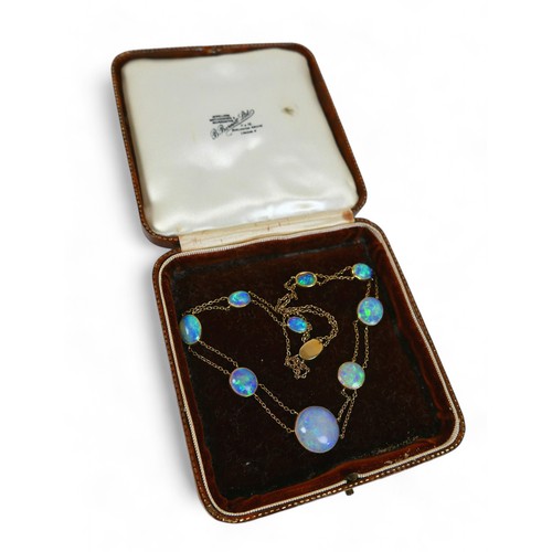 65 - An opal and yellow metal double strand necklace, made up of nine opals of graduating sizes, the cent... 