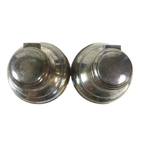 82 - A boxed pair of silver inkwells, maker M & J Birmingham 1930 with hinged lids, circular bases and gl... 