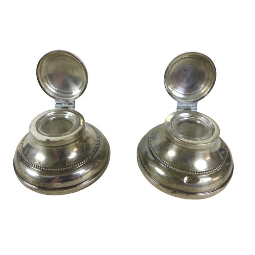 82 - A boxed pair of silver inkwells, maker M & J Birmingham 1930 with hinged lids, circular bases and gl... 