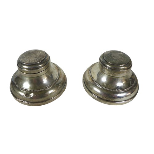 82 - A boxed pair of silver inkwells, maker M & J Birmingham 1930 with hinged lids, circular bases and gl... 