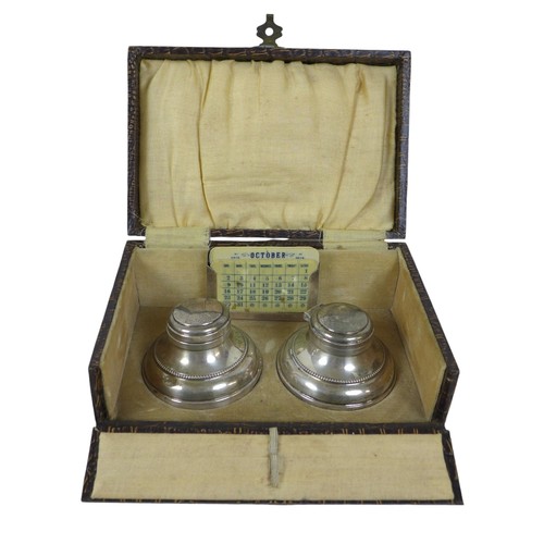 82 - A boxed pair of silver inkwells, maker M & J Birmingham 1930 with hinged lids, circular bases and gl... 