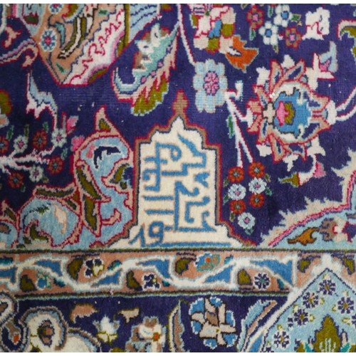 385 - A Persian hand knotted woolen carpet, with a blue field and stylized border, 405 by 308cm.