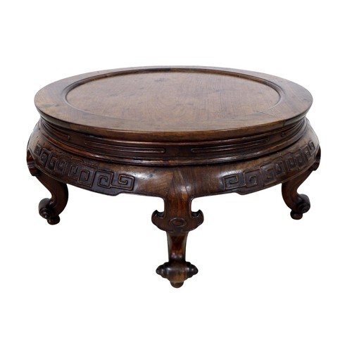 378 - A Chinese circular hardwood opium table, with a relief decorated frieze on four scroll feet, 77cm di... 