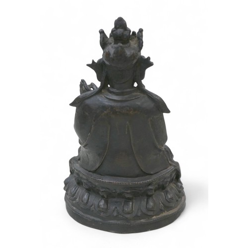 214 - A bronzed sculpture of Guanyin in a seated position, 21cm high.